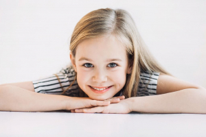 Niña mostrando el correcto desarrollo de sus dientes y mordida