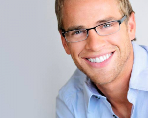 Hombre adulto mostrando resultados de su tratamiento ortodóncico